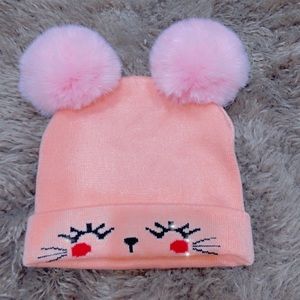 Rosey cat winter hat with two pom-poms on top.
